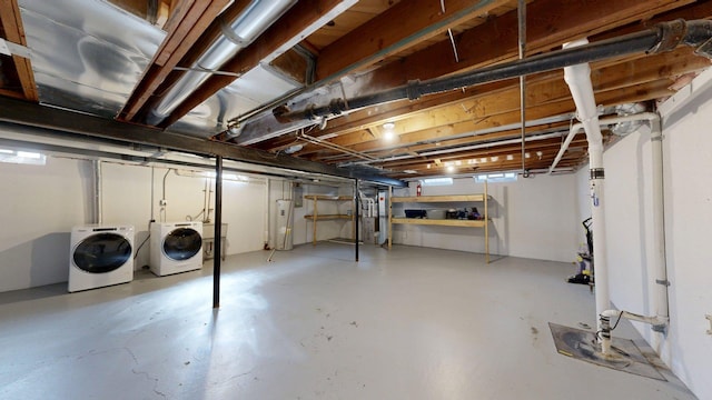 unfinished below grade area with electric water heater, washer and clothes dryer, and a sink