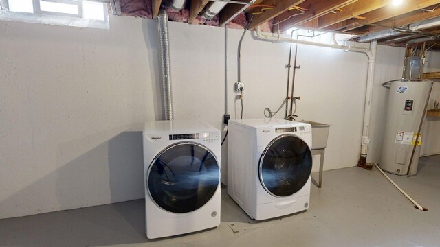 laundry room featuring electric water heater, independent washer and dryer, and laundry area