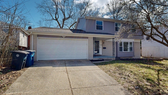 traditional home featuring driveway, a garage, and brick siding