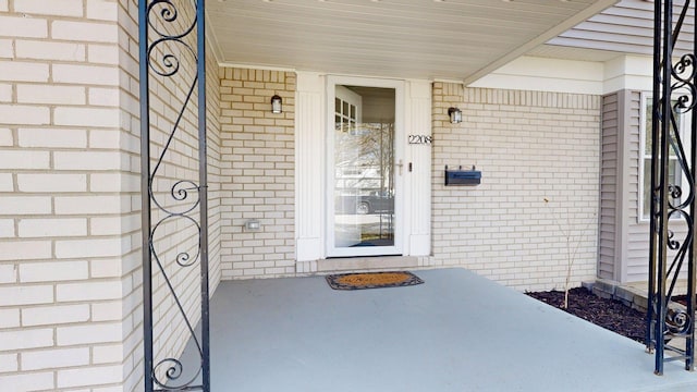 entrance to property featuring brick siding