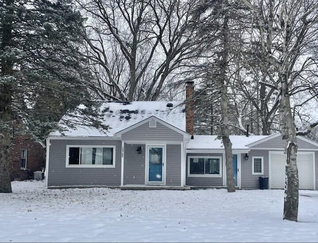 single story home featuring a chimney and a garage