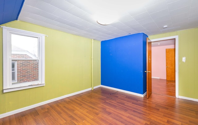 empty room featuring wood finished floors and baseboards