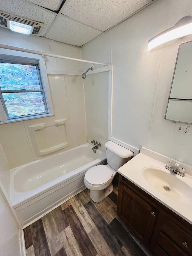 509 Mccourtie St, Kalamazoo, MI 49008 - full bathroom with vanity, toilet, visible vents, a drop ceiling, and wood finished floors