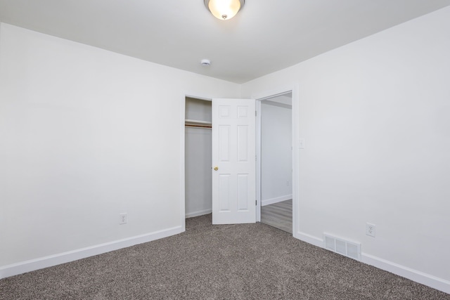 unfurnished bedroom featuring baseboards, visible vents, carpet, and a closet