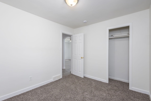 unfurnished bedroom featuring a closet, carpet, visible vents, and baseboards