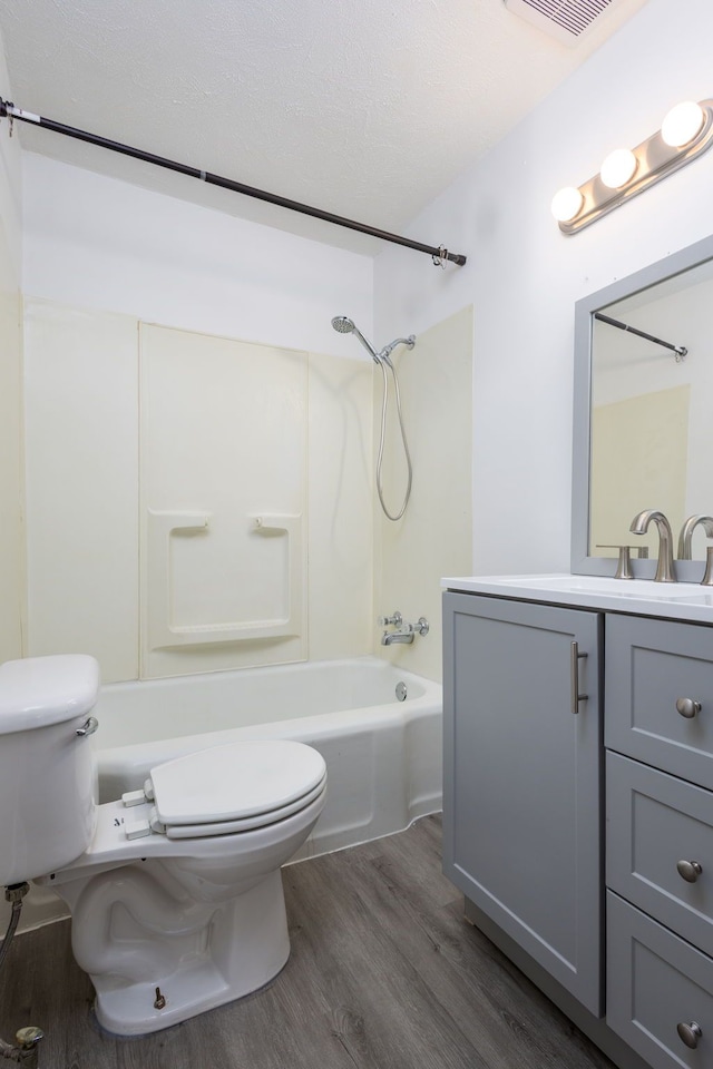 full bathroom featuring shower / washtub combination, wood finished floors, visible vents, toilet, and vanity