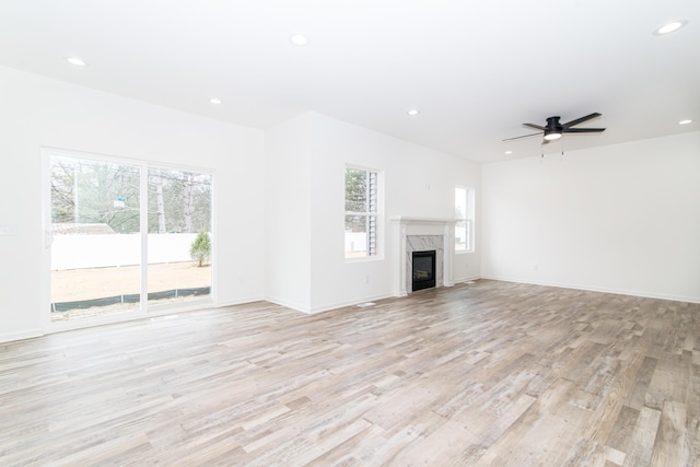 20233 Sunset Ave, Livonia, MI 48152 - unfurnished living room featuring baseboards, light wood-type flooring, recessed lighting, a ceiling fan, and a premium fireplace