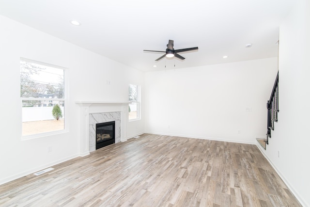 20233 Sunset Ave, Livonia, MI 48152 - unfurnished living room featuring visible vents, a ceiling fan, plenty of natural light, and a high end fireplace