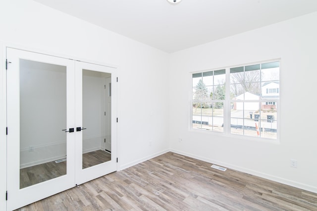 20233 Sunset Ave, Livonia, MI 48152 - spare room featuring french doors, baseboards, visible vents, and wood finished floors