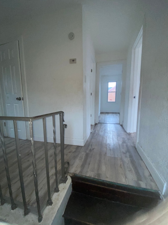 stairway featuring wood finished floors and baseboards