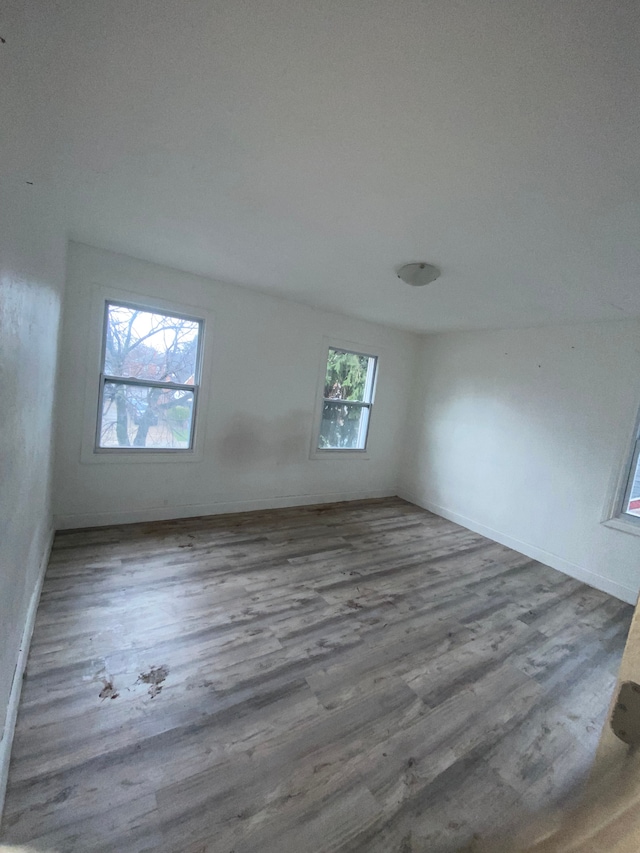 unfurnished room with wood finished floors and baseboards