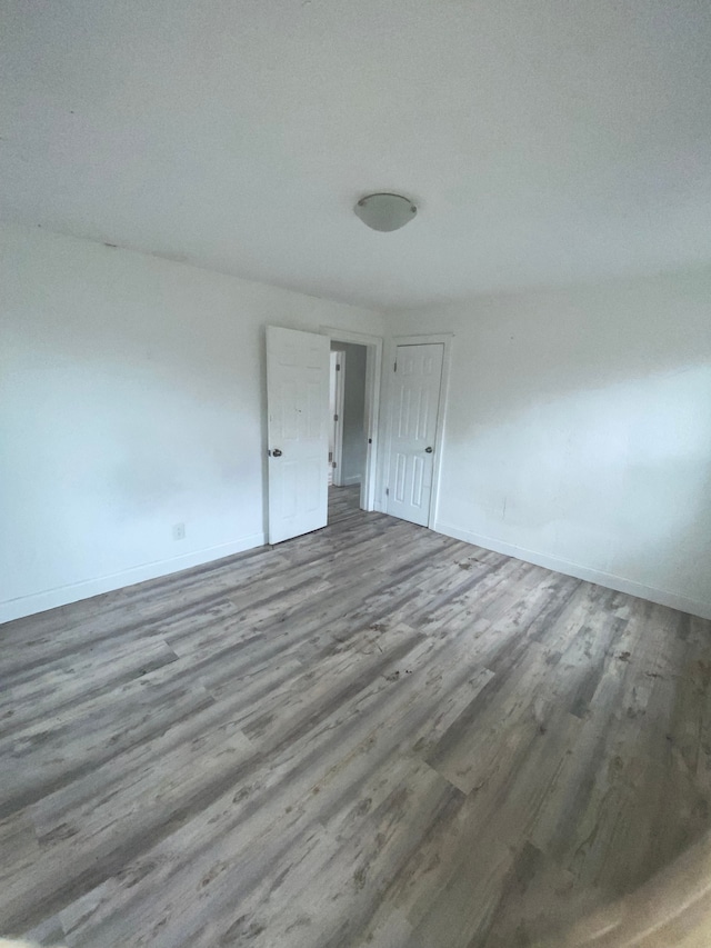 empty room featuring baseboards and wood finished floors