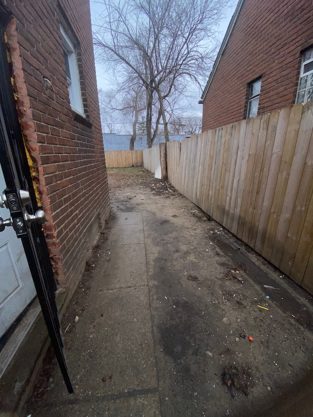 exterior space featuring brick siding and fence