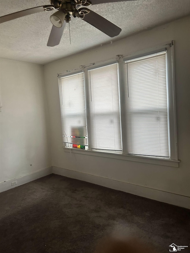 455 Kitchener St, Detroit, MI 48215 - unfurnished room featuring a textured ceiling, ceiling fan, dark carpet, and baseboards