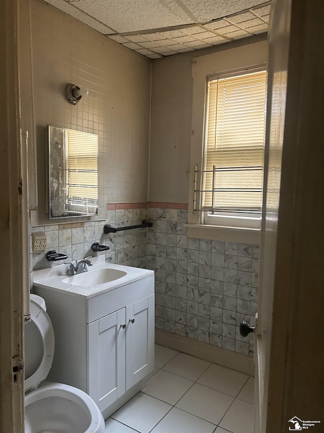 455 Kitchener St, Detroit, MI 48215 - bathroom featuring tile walls, tile patterned flooring, vanity, toilet, and a paneled ceiling