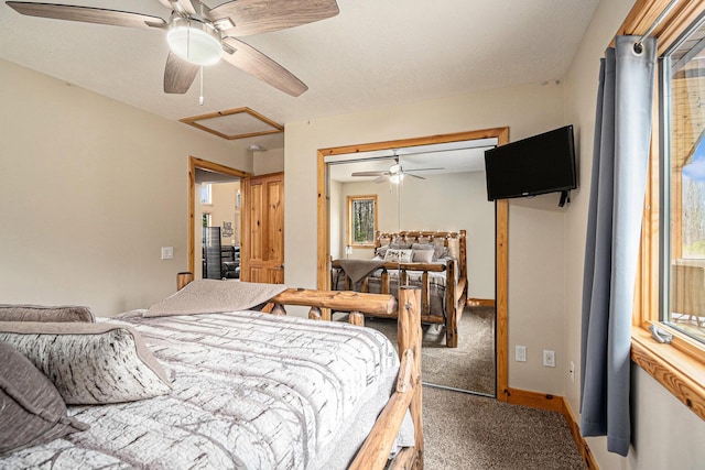 carpeted bedroom featuring a closet, multiple windows, attic access, and a ceiling fan