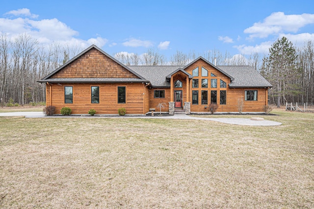 rustic home featuring a front lawn and a shingled roof