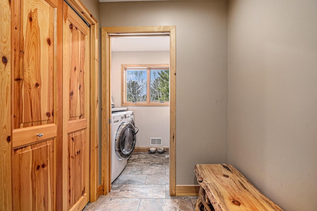 laundry room with baseboards, washer / dryer, laundry area, visible vents, and stone tile floors