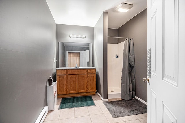 full bathroom featuring tile patterned floors, a stall shower, baseboards, and vanity