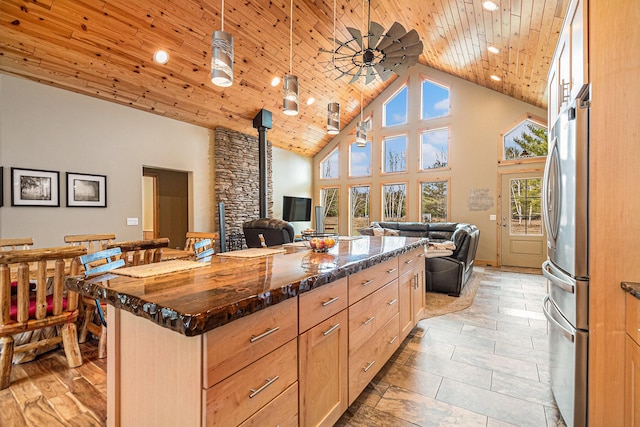 kitchen with open floor plan, wooden ceiling, freestanding refrigerator, and high vaulted ceiling