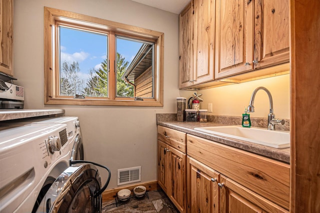 laundry room featuring baseboards, visible vents, washer and clothes dryer, cabinet space, and a sink