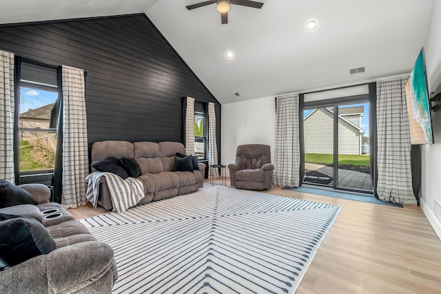 living room featuring wood finished floors, visible vents, a ceiling fan, and plenty of natural light