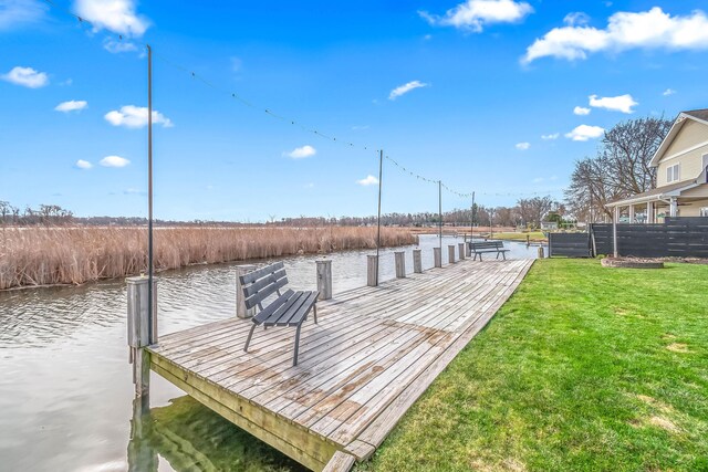 dock area with a water view and a yard