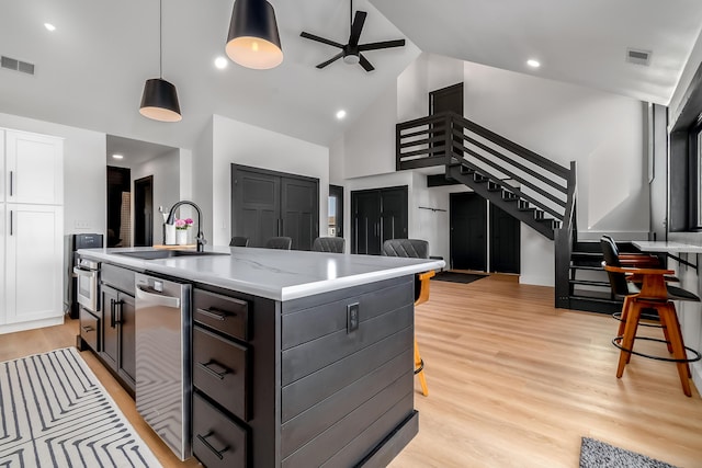 kitchen featuring open floor plan, a sink, a ceiling fan, and visible vents