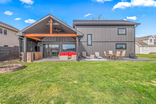 back of property with a yard, ceiling fan, fence, and a patio area