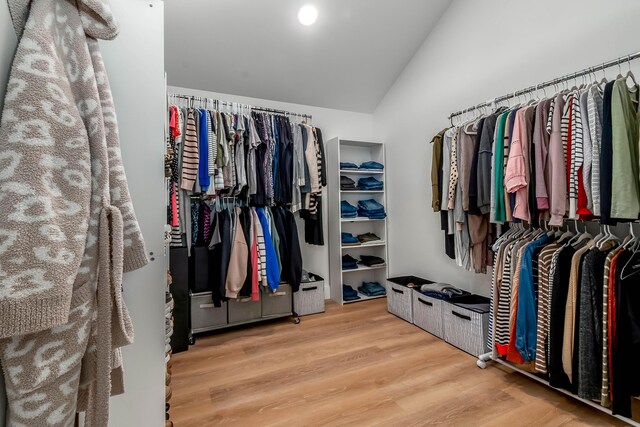walk in closet featuring wood finished floors and vaulted ceiling