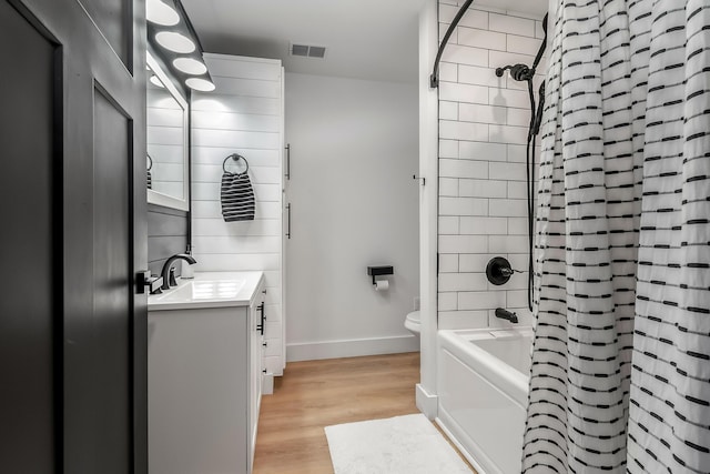 full bath with vanity, baseboards, toilet, visible vents, and wood finished floors