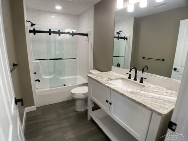 bathroom with shower / bath combination with glass door, recessed lighting, vanity, toilet, and visible vents