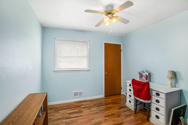 office space featuring visible vents, baseboards, a ceiling fan, and wood finished floors