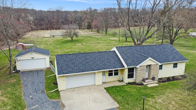 single story home featuring a front yard, a detached garage, and roof with shingles