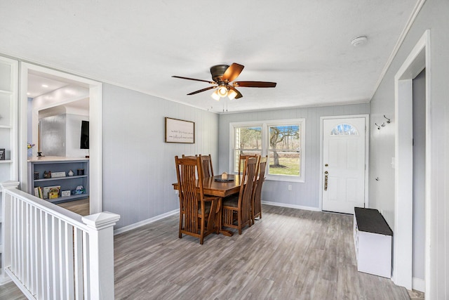 dining space featuring ceiling fan, baseboards, ornamental molding, and wood finished floors