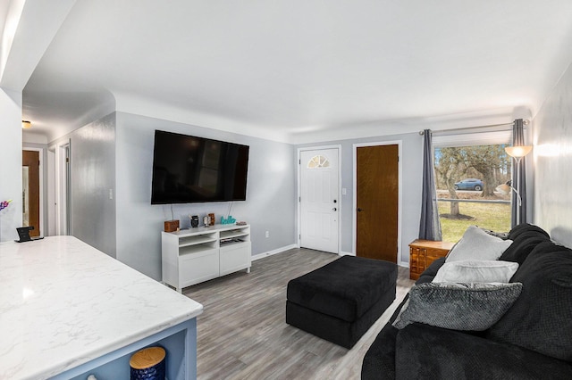 living area featuring light wood-style floors and baseboards