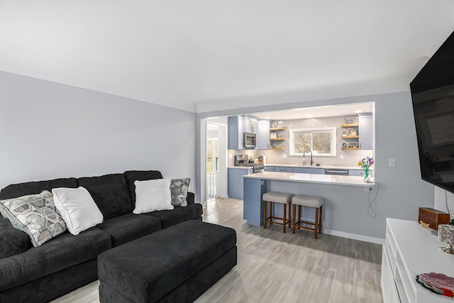 living room featuring light wood-type flooring and baseboards