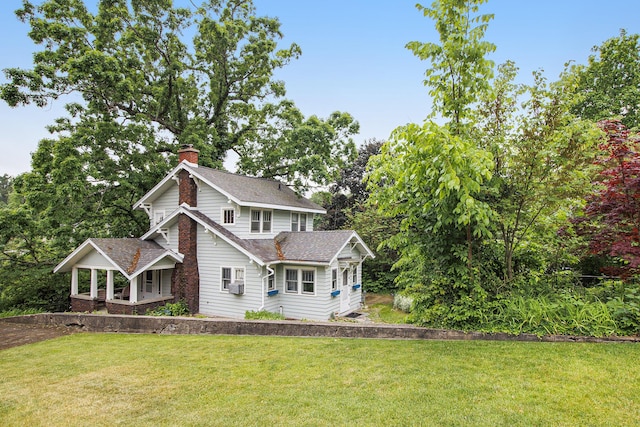 165 Honey Ln, Battle Creek, MI 49015 - view of front of house with a chimney, a front yard, covered porch, and roof with shingles