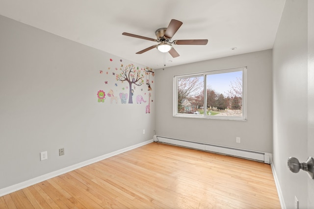 spare room featuring wood-type flooring, a baseboard radiator, baseboards, and ceiling fan