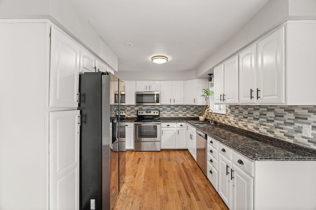 kitchen featuring a sink, appliances with stainless steel finishes, tasteful backsplash, and white cabinetry