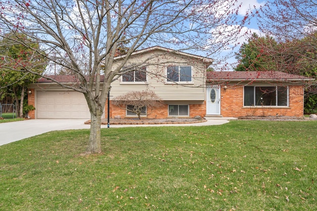tri-level home featuring a garage, driveway, a front lawn, and brick siding