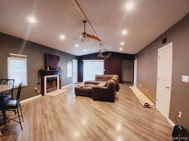 20446 Williamson St, Clinton Township, MI 48035 - living area featuring vaulted ceiling, wood finished floors, a ceiling fan, a fireplace with flush hearth, and baseboards