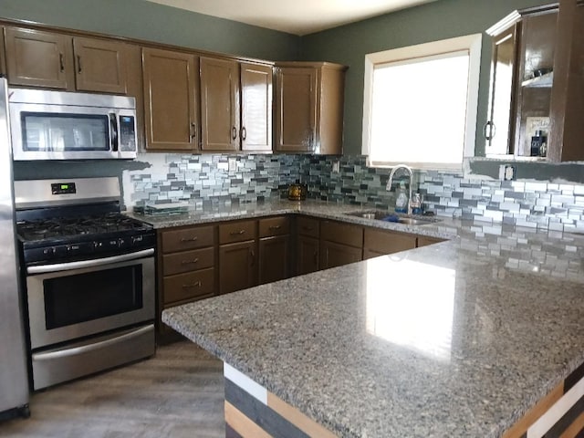 20446 Williamson St, Clinton Township, MI 48035 - kitchen with appliances with stainless steel finishes, a sink, tasteful backsplash, wood finished floors, and light stone counters
