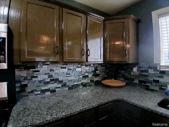 20446 Williamson St, Clinton Township, MI 48035 - kitchen featuring backsplash, dark stone counters, and dark brown cabinetry