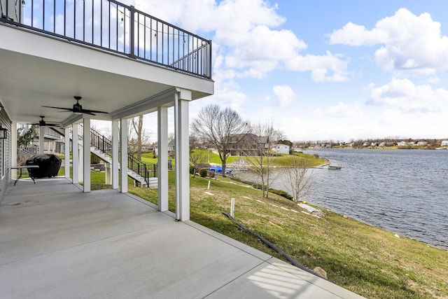 view of patio with ceiling fan, a balcony, a grill, a water view, and stairway