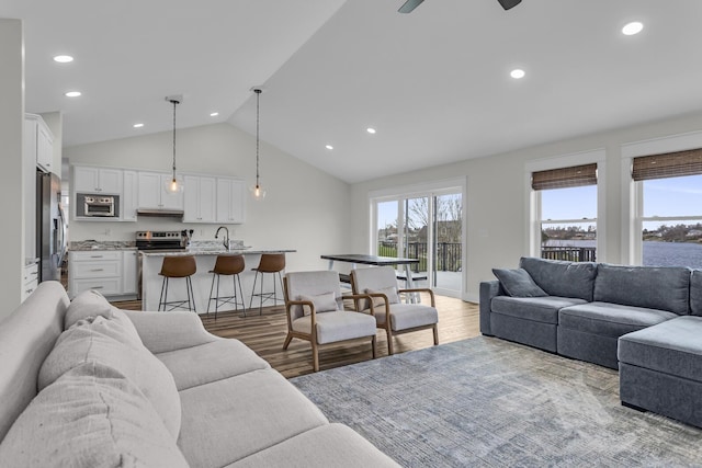 living area featuring recessed lighting, a ceiling fan, light wood finished floors, and vaulted ceiling