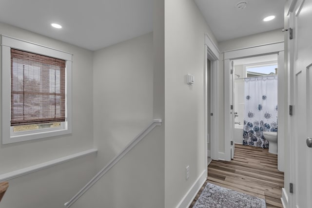 hall with recessed lighting, baseboards, an upstairs landing, and wood finished floors
