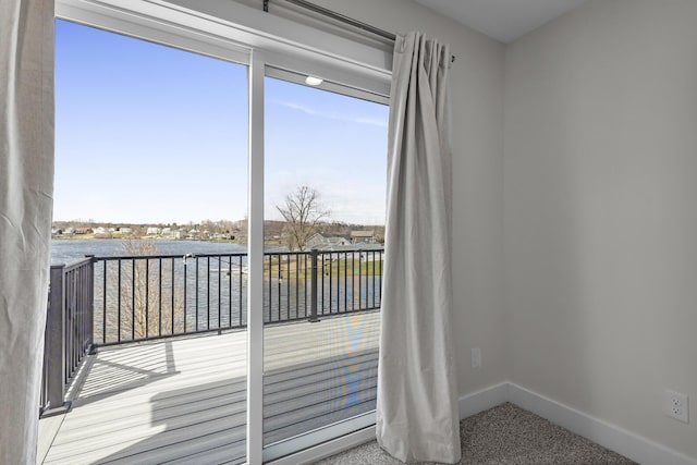 doorway to outside featuring carpet flooring and baseboards