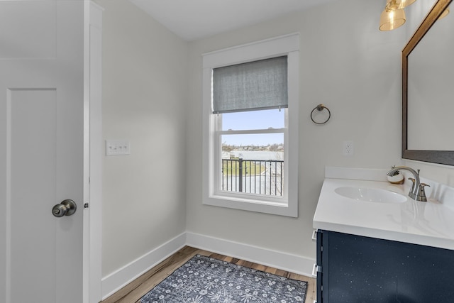 bathroom with vanity, baseboards, and wood finished floors