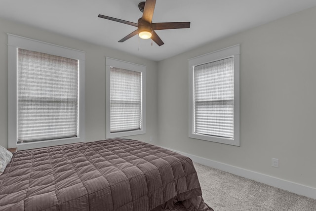 carpeted bedroom featuring baseboards and ceiling fan